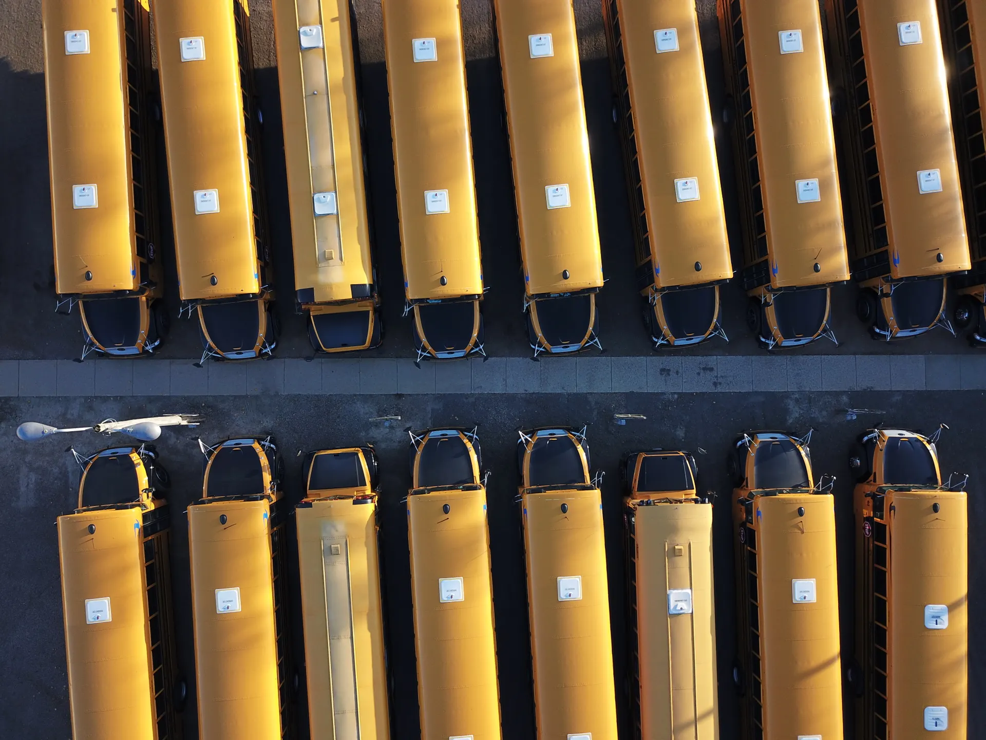 Aerial view of yellow school buses parked in neat rows, representing the scale of K-12 public education